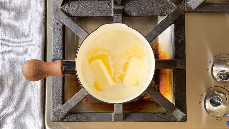 Chauffage de crème et de beurre épais dans la casserole sur la cuisinière