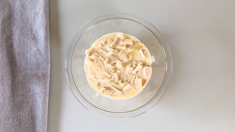 Crème chaude et chocolat blanc dans un bol en verre