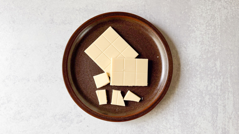 Barre de chocolat blanc sur assiette brune