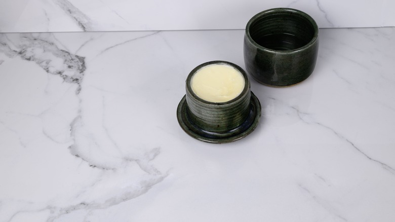 Une cloche de beurre noir sur un comptoir en marbre
