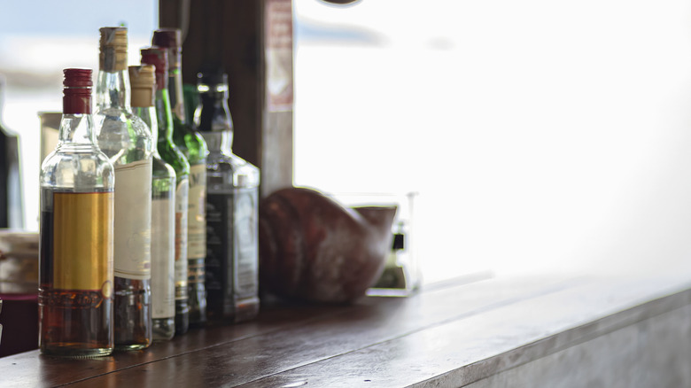 Diverses bouteilles d'alcool sur une barre en bois