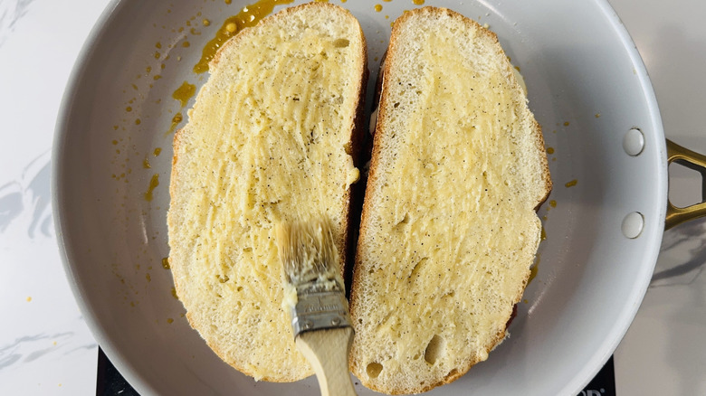 Brosser le fromage grillé à la pizza avec du beurre à l'ail