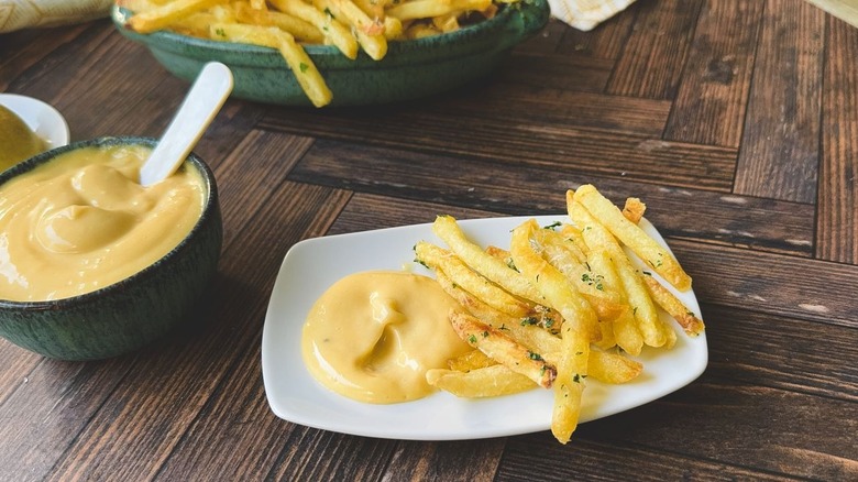 Aïoli à double truffe maison avec frites sur assiette de service