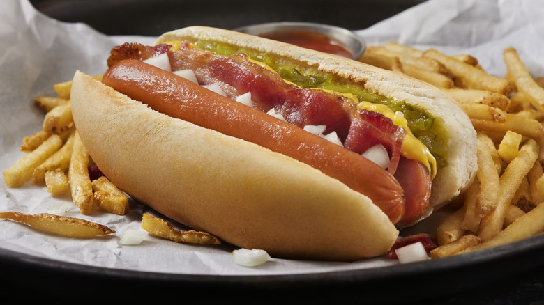 Un hot-dog divisé avec des frites et des garnitures.