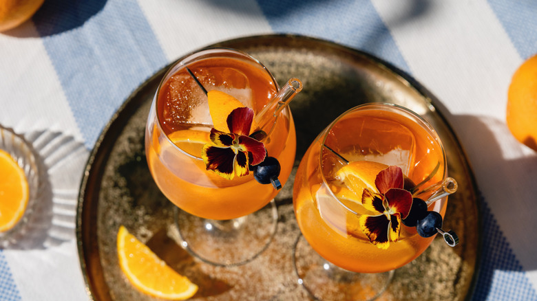 Cocktails orange avec des tranches d'orange assises sur un plat de service rond