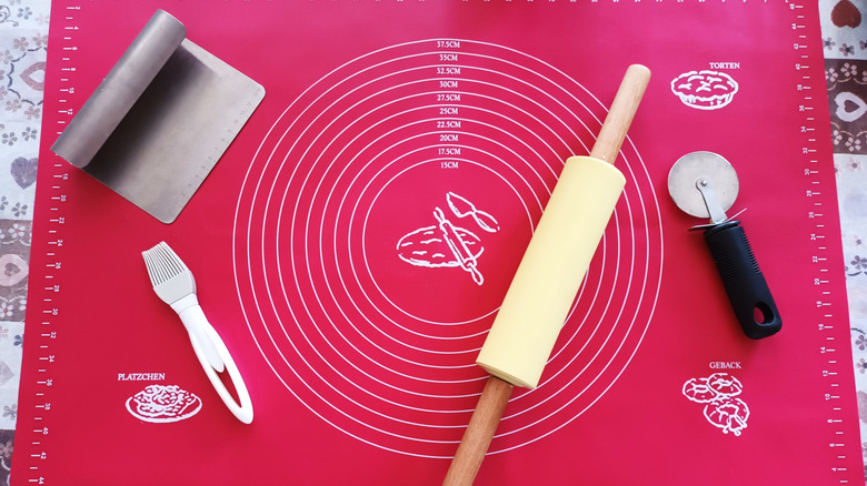 Un tapis de cuisson en silicone rose vif et des outils de cuisson