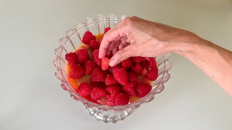 Superposer des framboises fraîches dans un plat de bagatelle