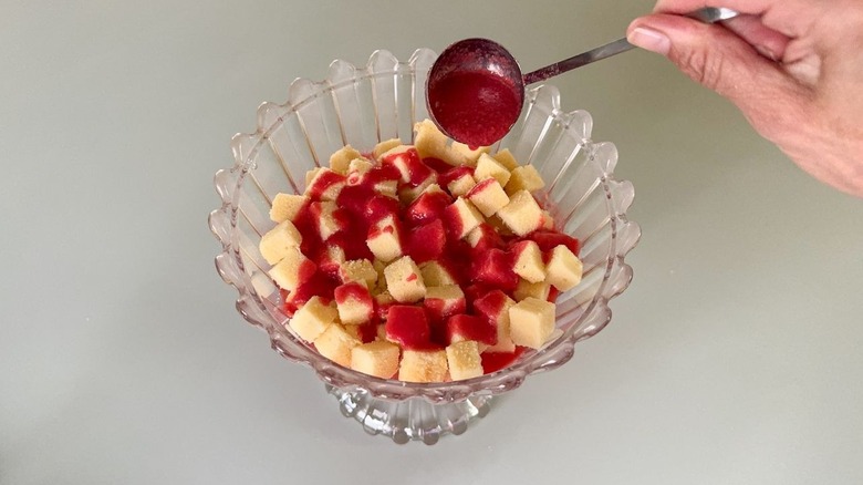 Purée de framboise arrosée sur des cubes Poundcake dans un plat de bagatelle