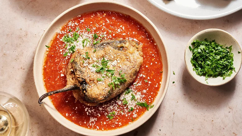 Assiette bronzée de chiles rellenos avec sauce guajillo chili garnie de la coriandre hachée et de la fresque dureso