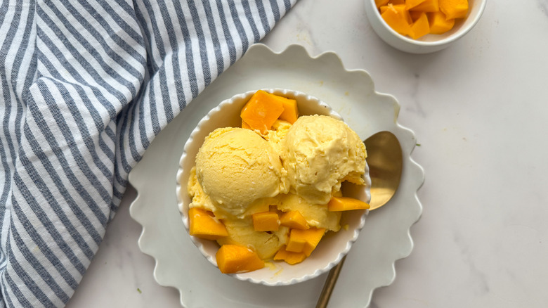 Mango Ice Cream in Bowl avec des morceaux de mangue sur le dessus