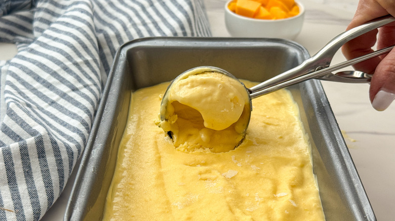 Crème glacée à la mangue à la main de la casserole à pain