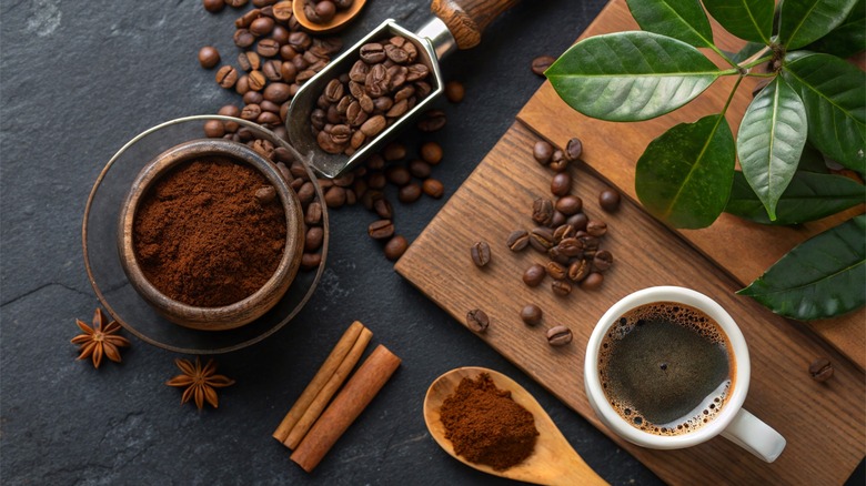 Café brassé sur la table à côté de l'expresso, des épices et des grains