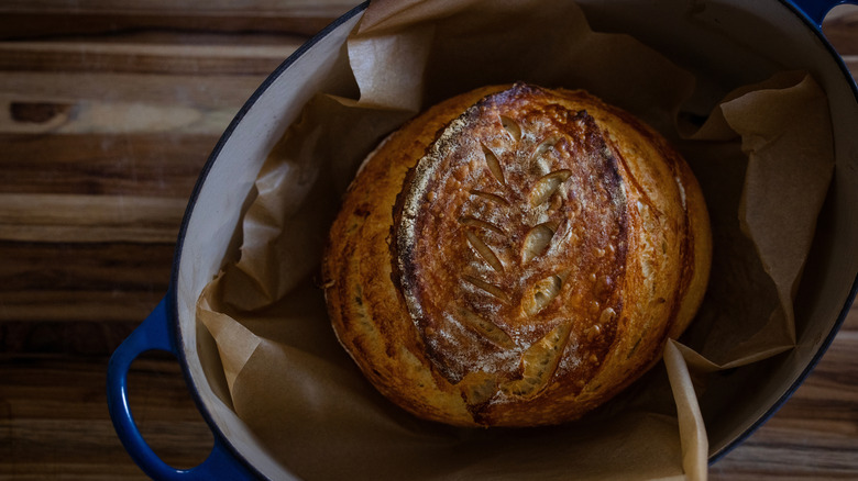 Miche de pain au levain maison fraîchement cuite reposant dans une cocotte