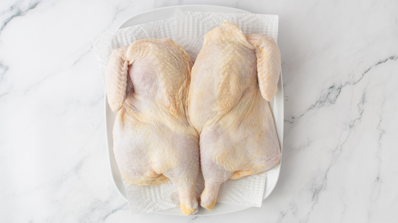 poulet cru sur une serviette en papier blanc