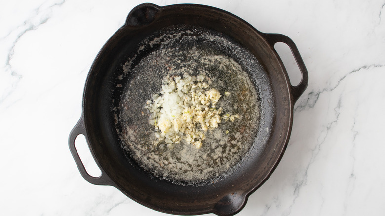 oignons hachés dans une poêle noire