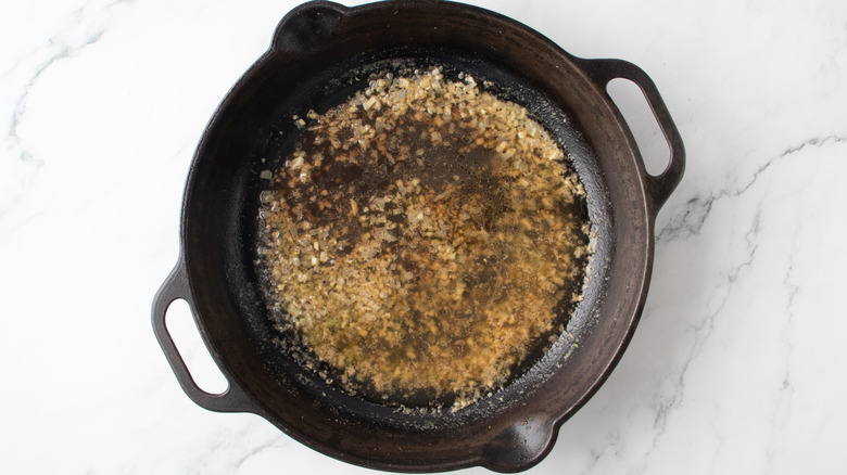 faire revenir le liquide avec les oignons hachés dans une poêle noire