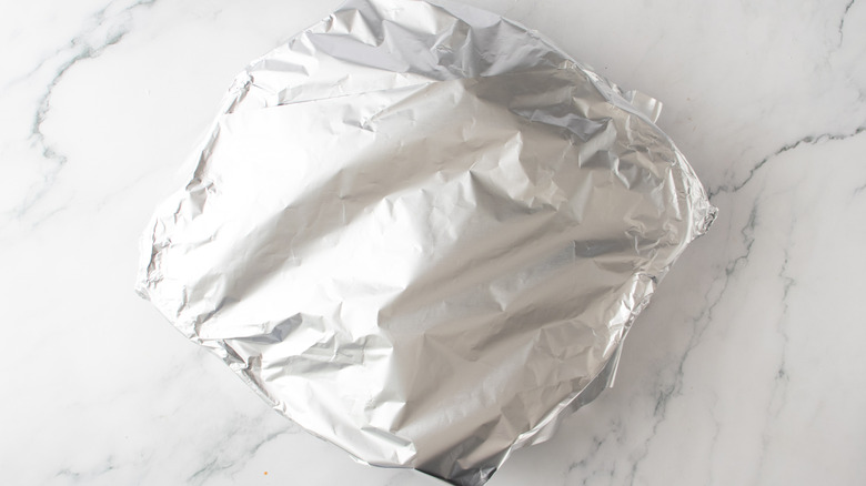 poêle recouverte de papier d'aluminium sur un comptoir de cuisine