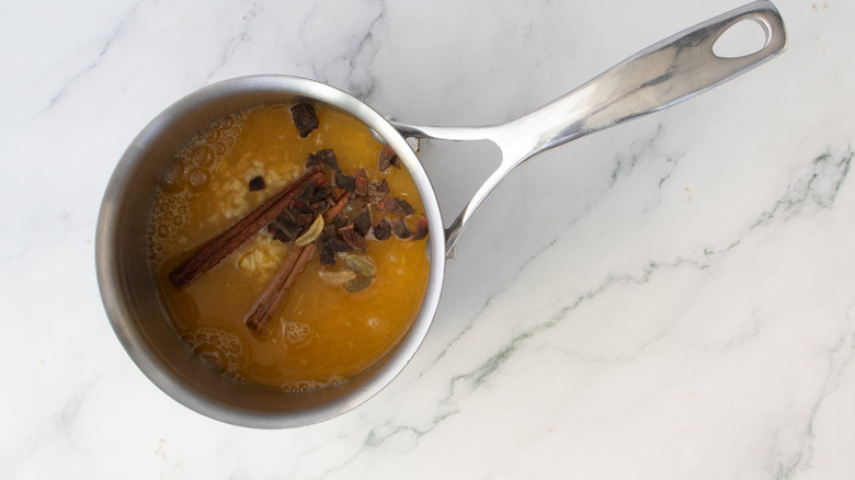 jus d'orange et épices dans un pot en métal
