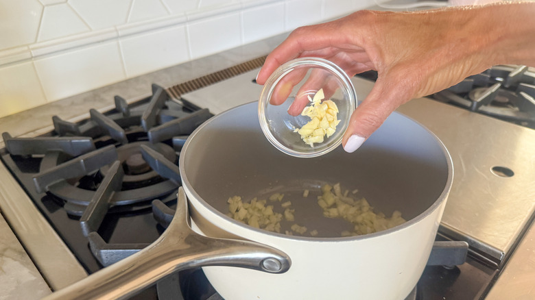 main ajoutant de l'ail