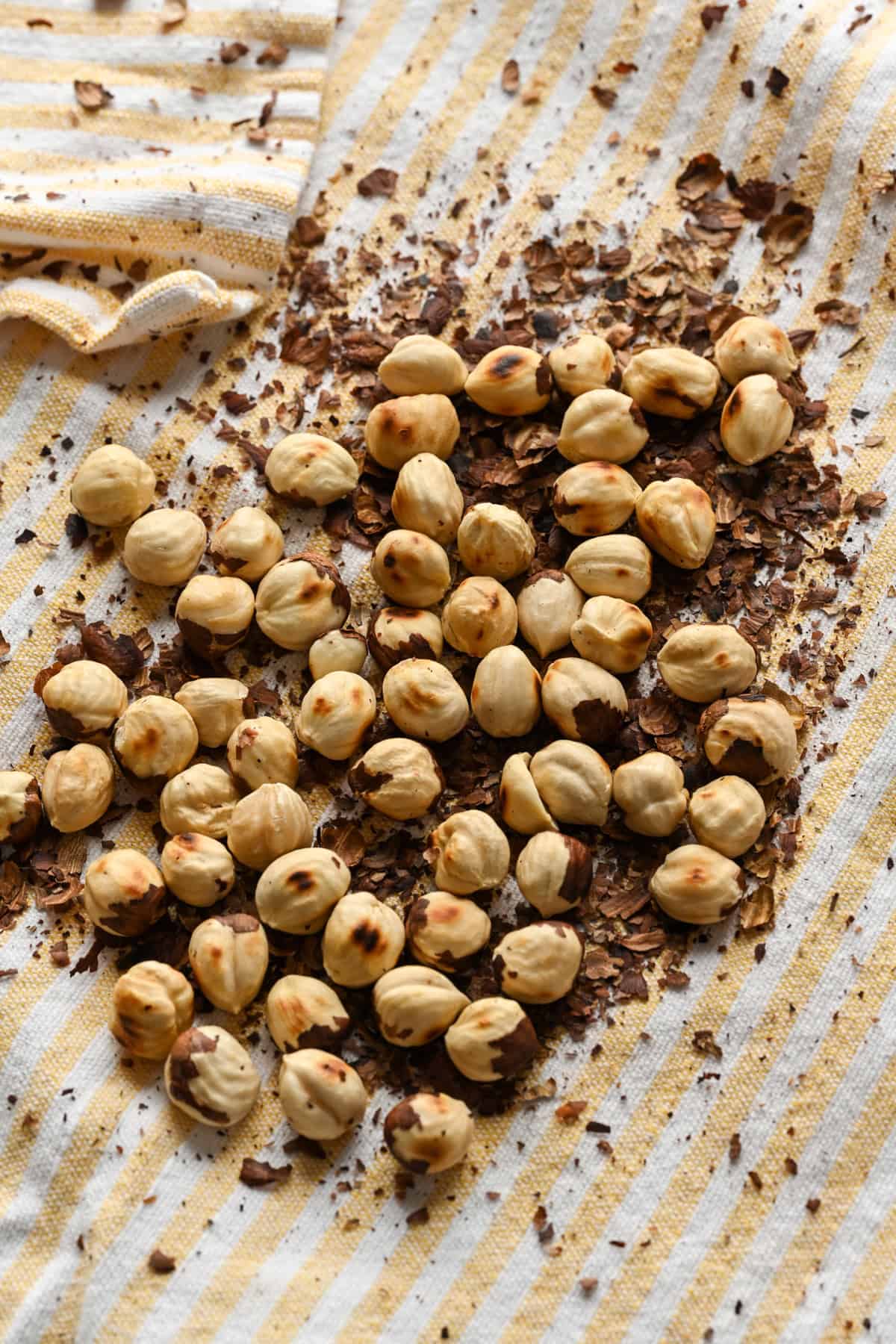 Vue rapprochée des noisettes sur un torchon avec les peaux autour.