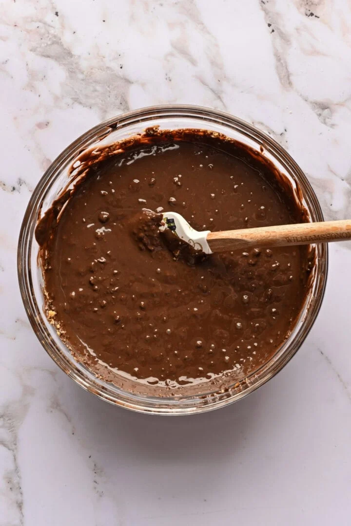 Chocolat fondu et noisettes hachées dans un bol après avoir mélangé.
