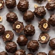 Vue aérienne des truffes ferrero rocher faites maison sur fond blanc avec quelques-unes coupées en deux.
