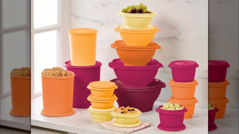Récipients et couvercles Tupperware Heritage Collection en jaune, orange et rose sur un comptoir de cuisine