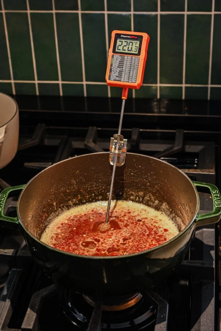 Vue de face de la gelée de poivre avec thermomètre en pot.