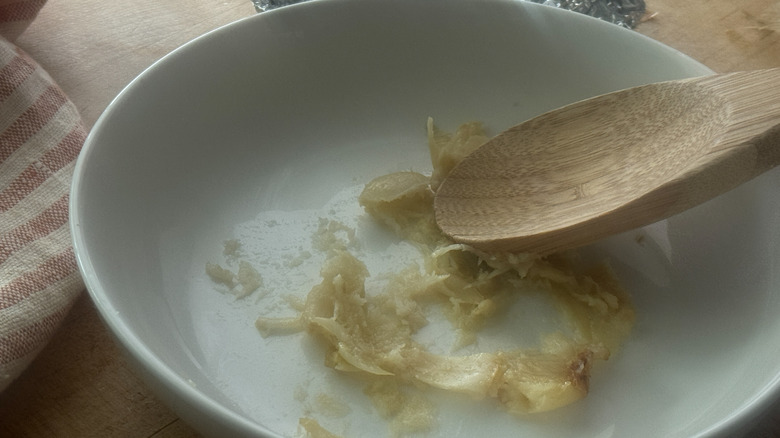 cuillère en bois écrasant des clous de girofle