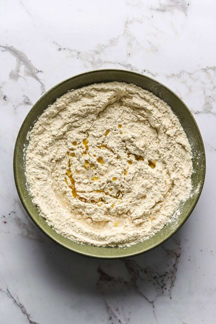 mélange de farine avec de l'eau et de l'huile d'olive ajoutées avant de mélanger.