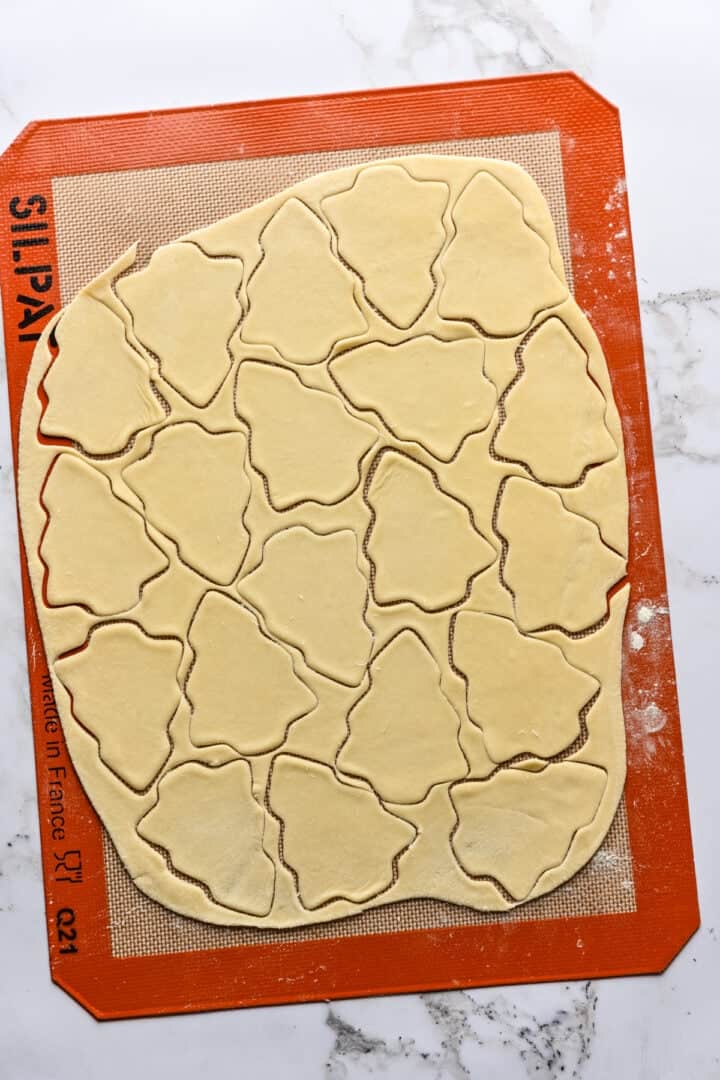 formes d'arbres de Noël découpées dans de la pâte à crackers.