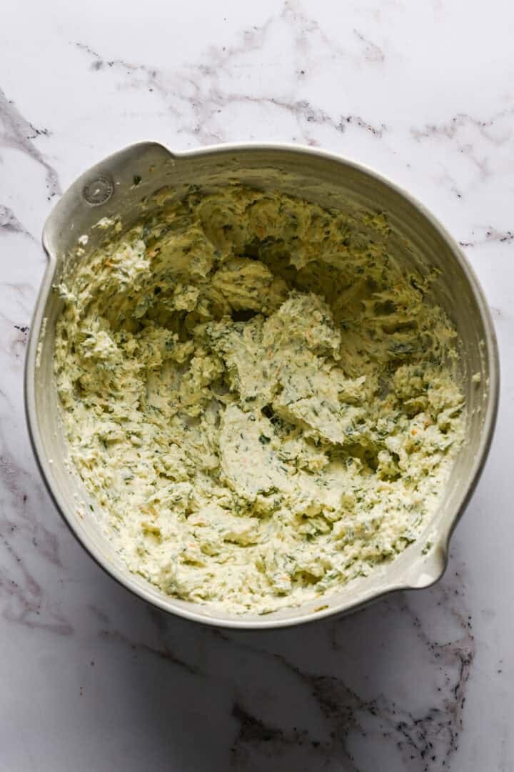 Mélange de boulettes de fromage dans un bol à mélanger blanc. 