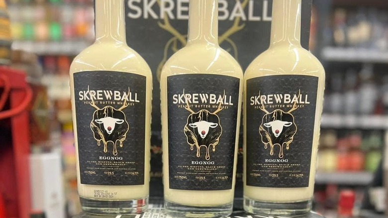 Trois bouteilles de Skrewball Peanut Butter Whisky Eggnog dans un magasin