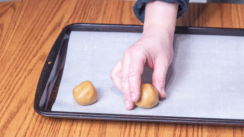 boules de beurre de cacahuète placées sur une plaque à biscuits
