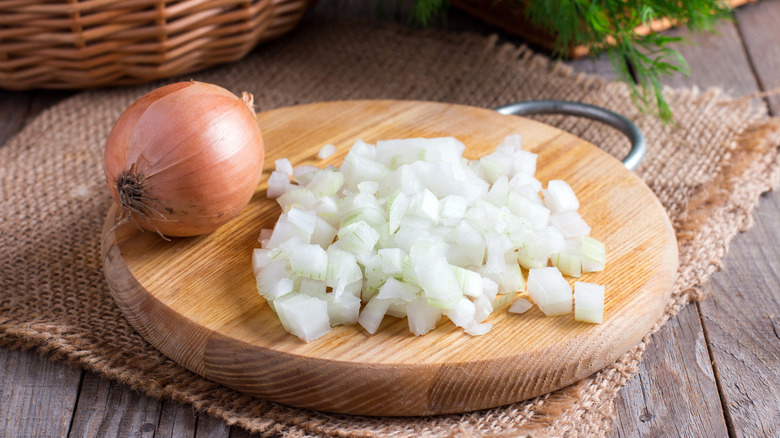 Oignons coupés en dés sur une planche à découper en bois