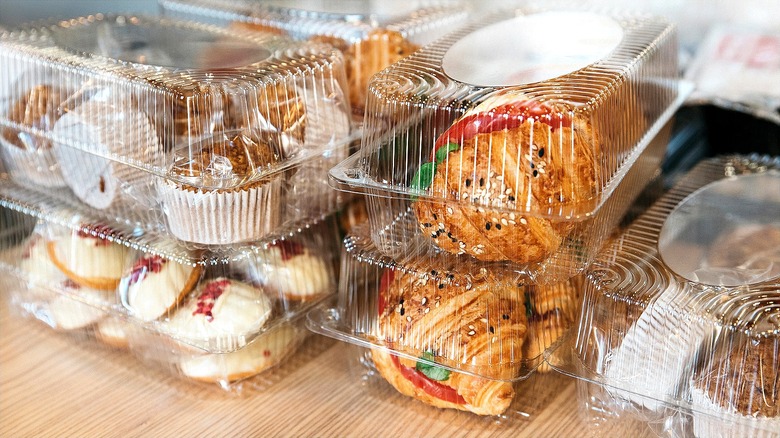 Croissants, muffins et biscuits avec pépites dans des contenants rectangulaires en plastique