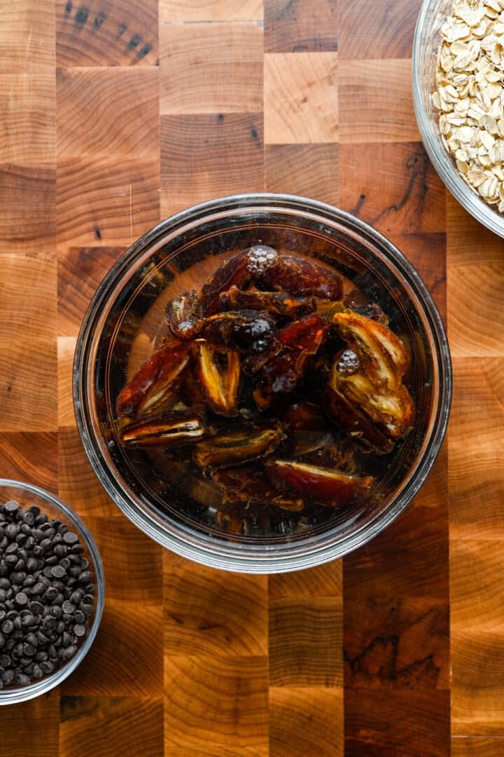 Dattes Medjool coupées en deux, trempées dans un bol d'eau.