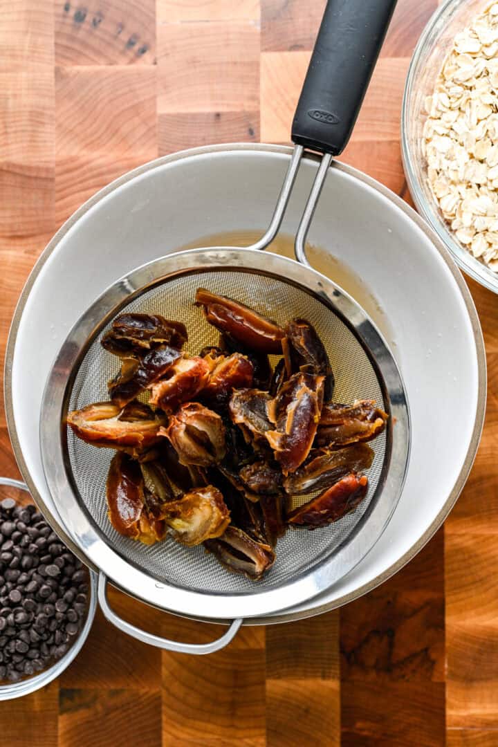 Dattes dans une passoire au dessus d'un bol.