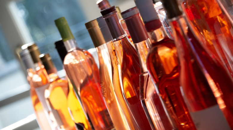 Plusieurs bouteilles de vin rosé sont coiffées ensemble.
