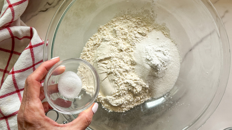 main ajoutant du sel au bol