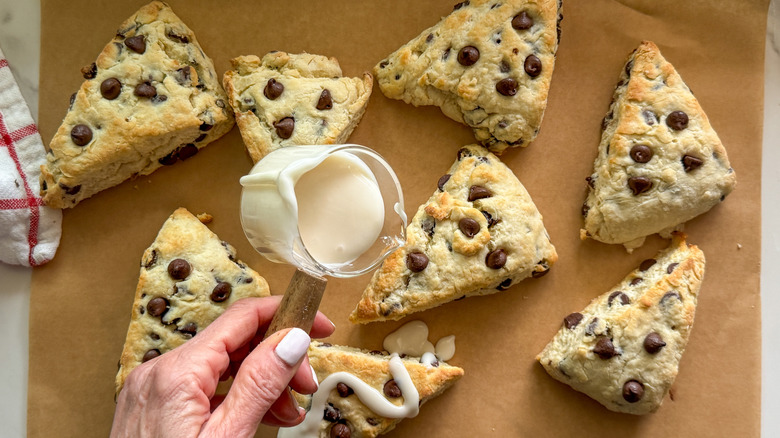 main ajoutant du glaçage aux scones