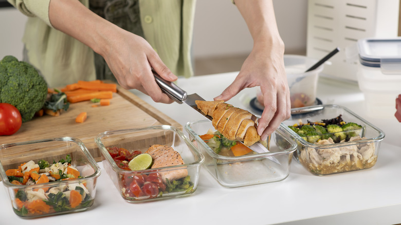 femme stockant des aliments préparés dans des récipients en verre