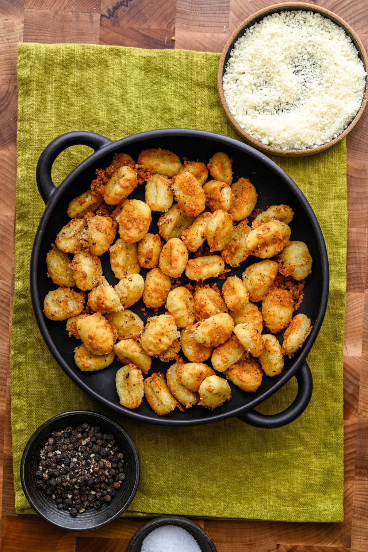 Gnocchis croustillants à la friteuse à air cacio e pepe dans un bol noir.