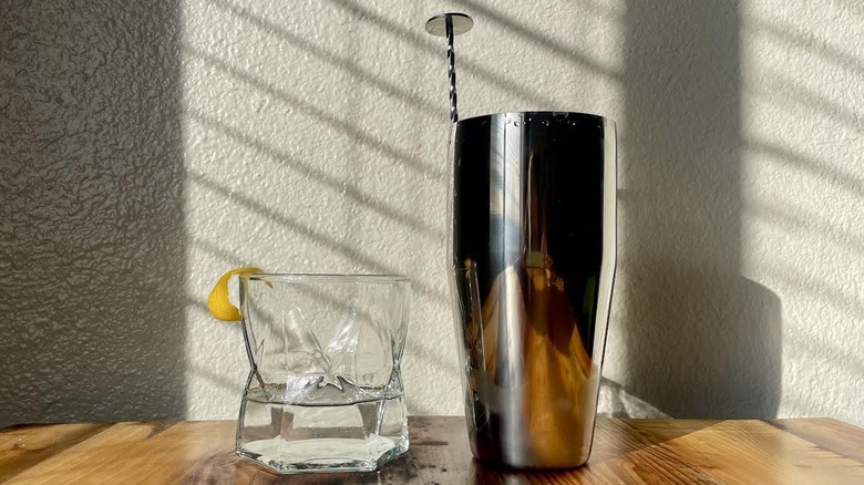 Martini classique avec une bande de citron et un shaker avec une cuillère.