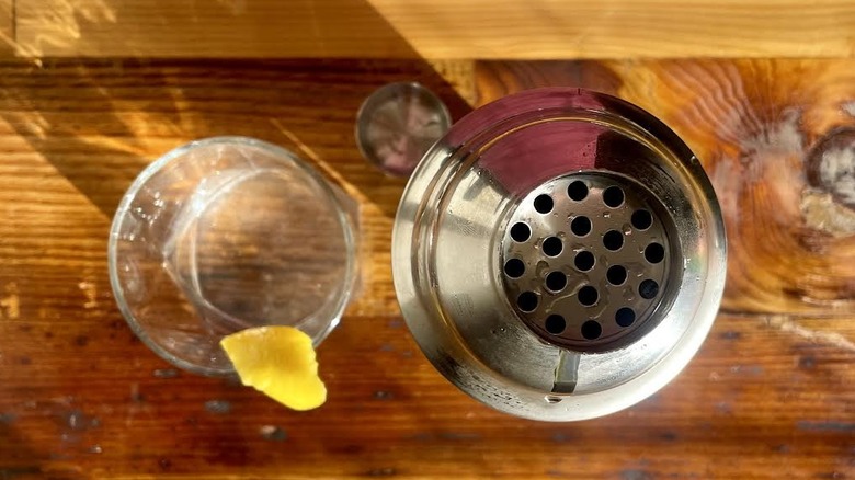 Vue aérienne d'un martini classique avec une bande de citron et un shaker.