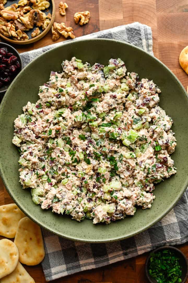 Salade de poulet aux canneberges et aux noix dans un bol à mélanger vert.