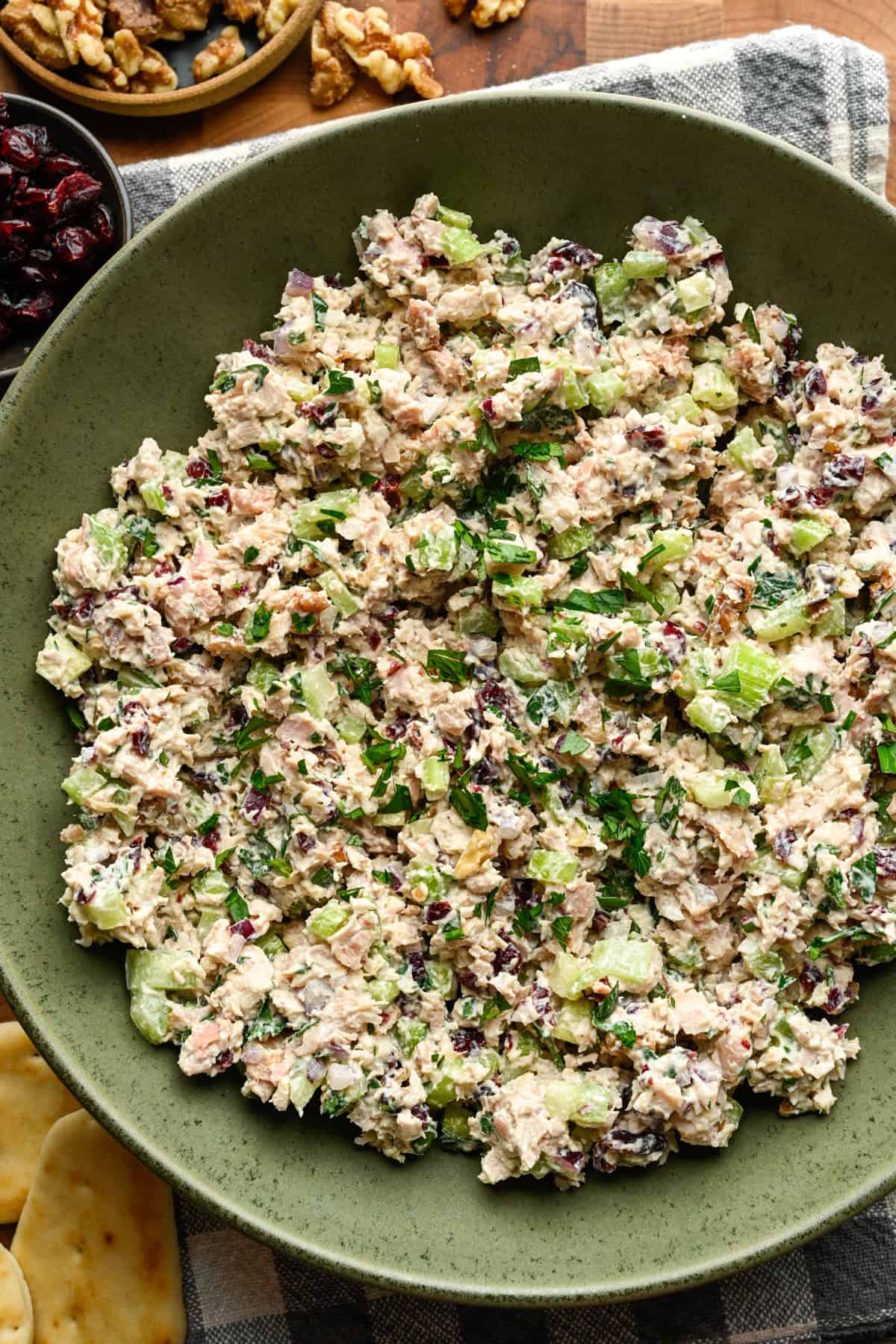 Vue rapprochée de la salade de poulet aux canneberges et aux noix dans un bol à mélanger vert.
