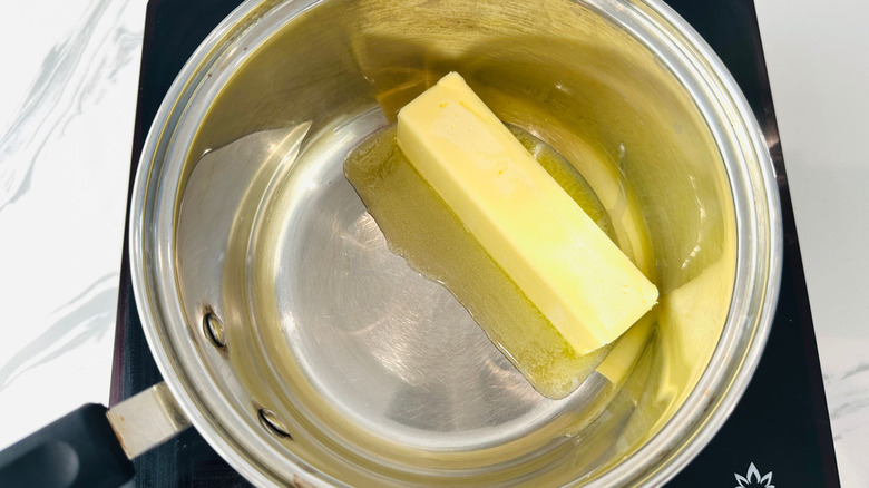 Bâton de beurre fondant dans une casserole