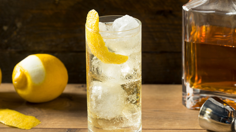 Un scotch et un soda avec un zeste de citron dans un verre highball.