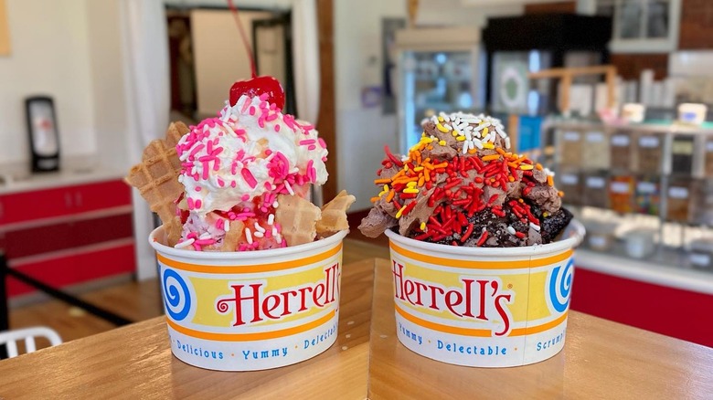 Deux tasses de glace de marque Herrell's avec garnitures posées sur une surface en bois